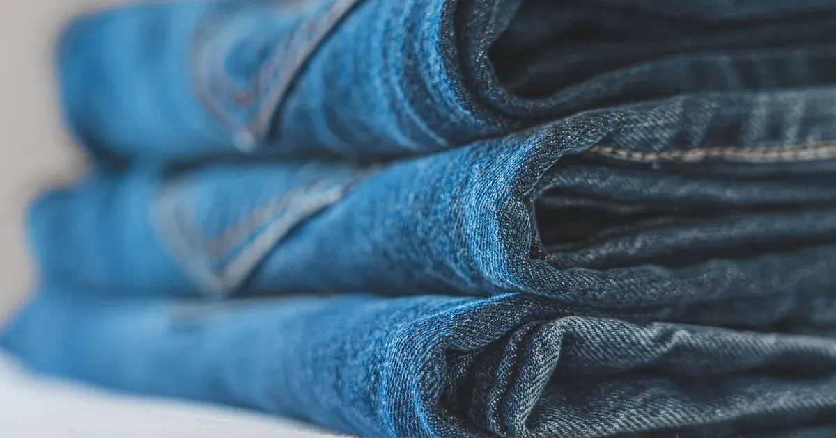 An open dresser drawer with t-shirts standing vertically in neat rows, every shirt visible at a glance. Natural light, clean white dresser.