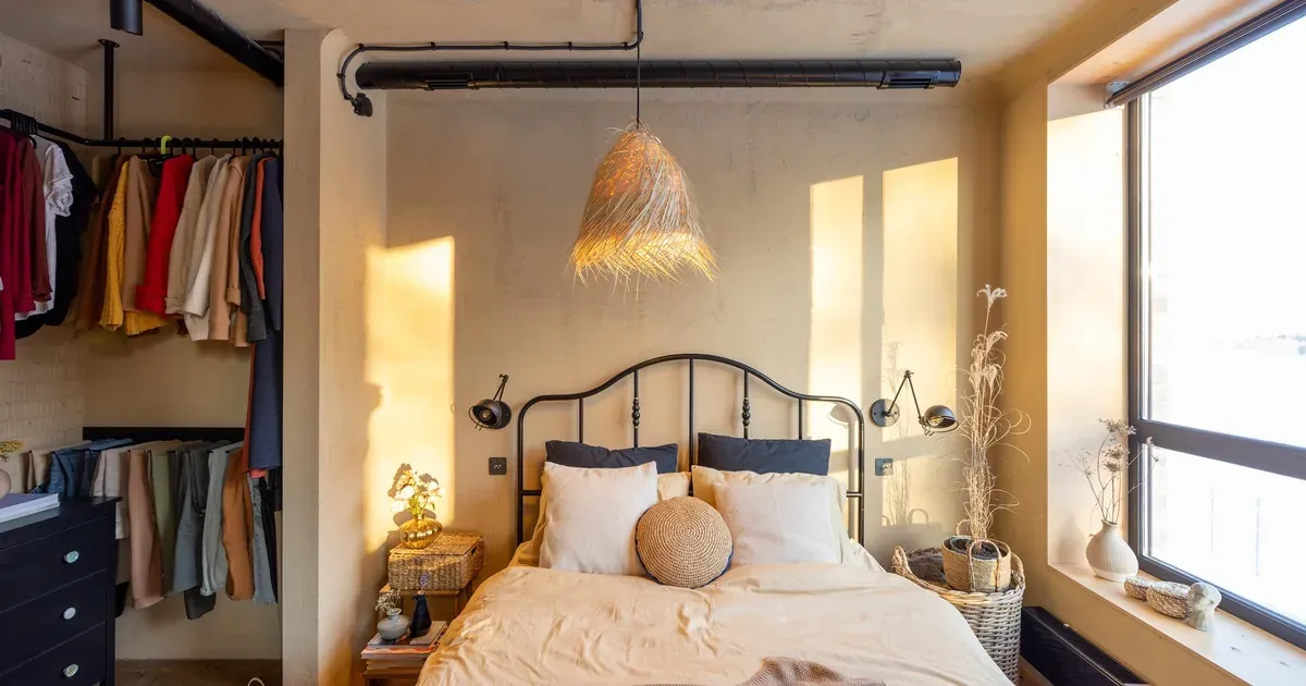 A neatly organized small bedroom with a storage bed frame, floating nightstand, and light neutral walls showing how functional and calm a small space can look.
