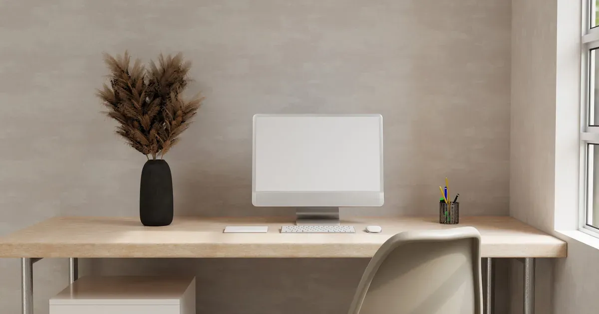 A small, tidy home office nook with a floating desk, contained cords, and wall storage, showing a functional setup in a compact space.