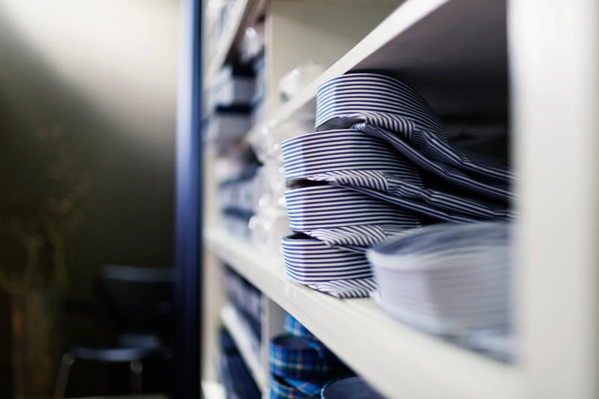 neatly folded long-sleeve shirts standing upright in dresser drawer