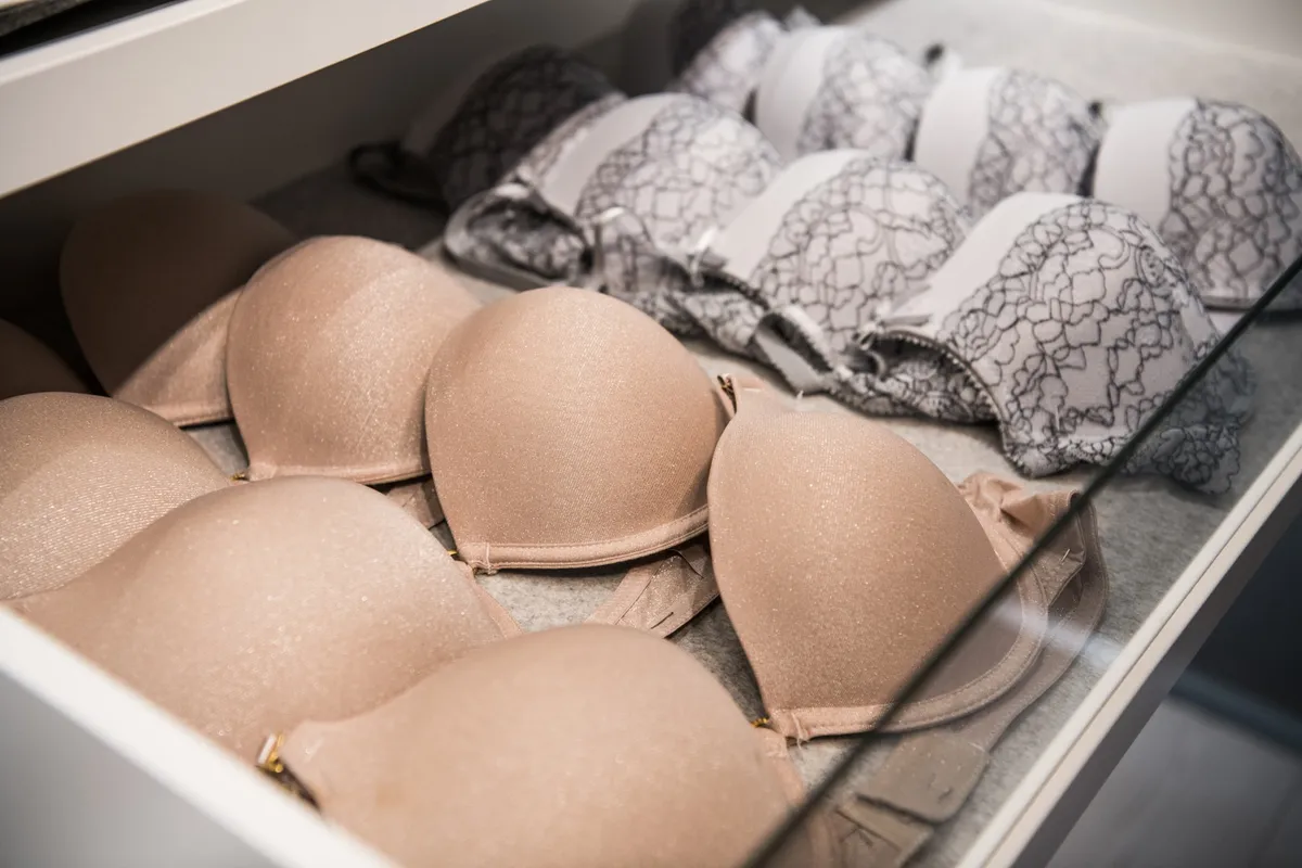 messy open dresser drawer with shirts stacked and tumbling