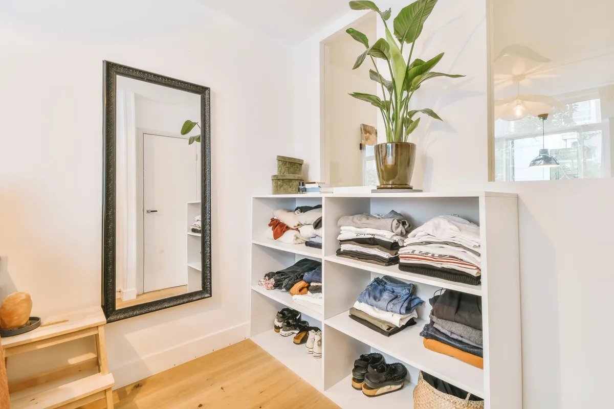 closet with double hanging rods holding shirts and pants
