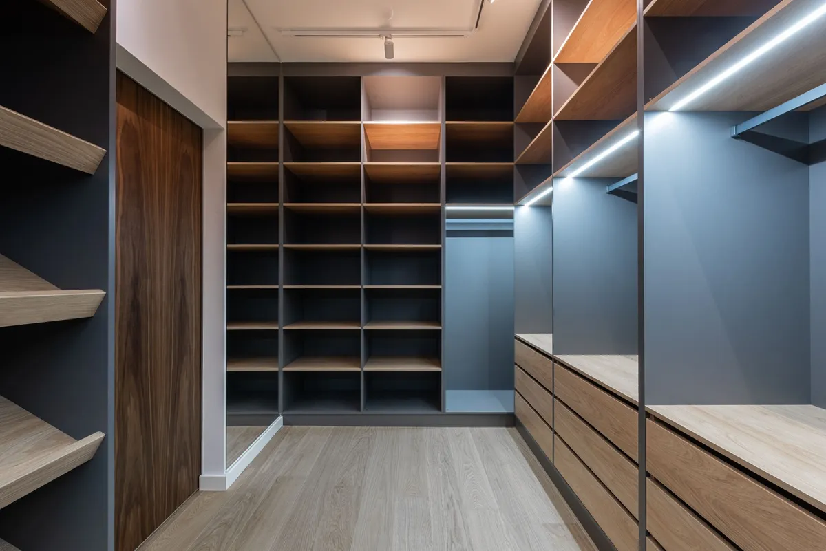 empty small closet with clothes sorted in piles on bed
