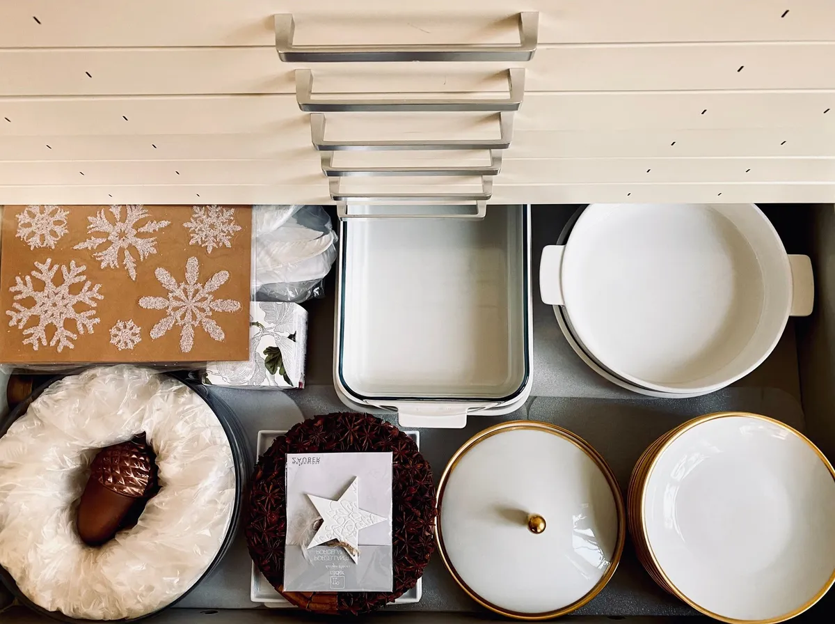cluttered kitchen counter with miscellaneous items piled near sink