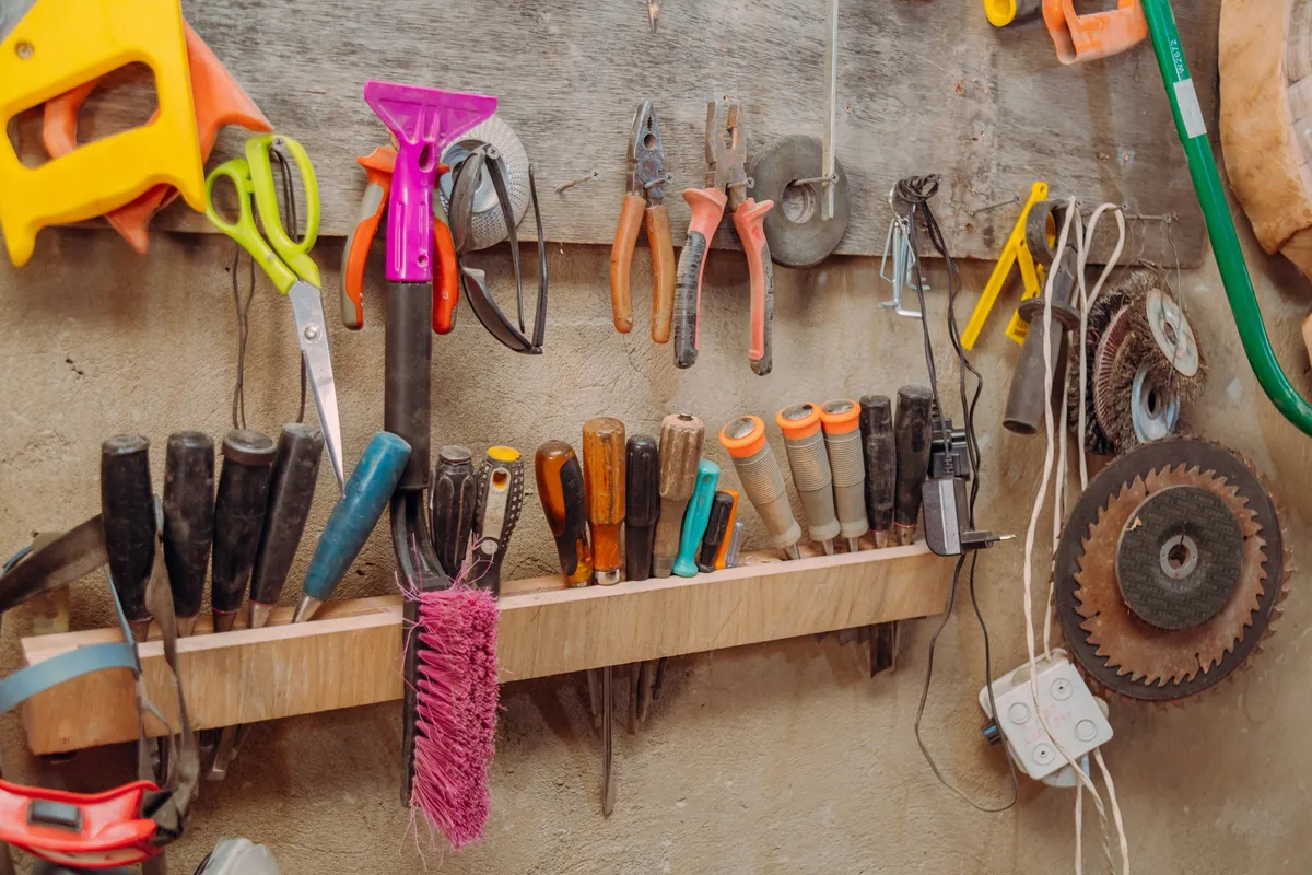 garage slatwall panel with hooks and baskets holding tools