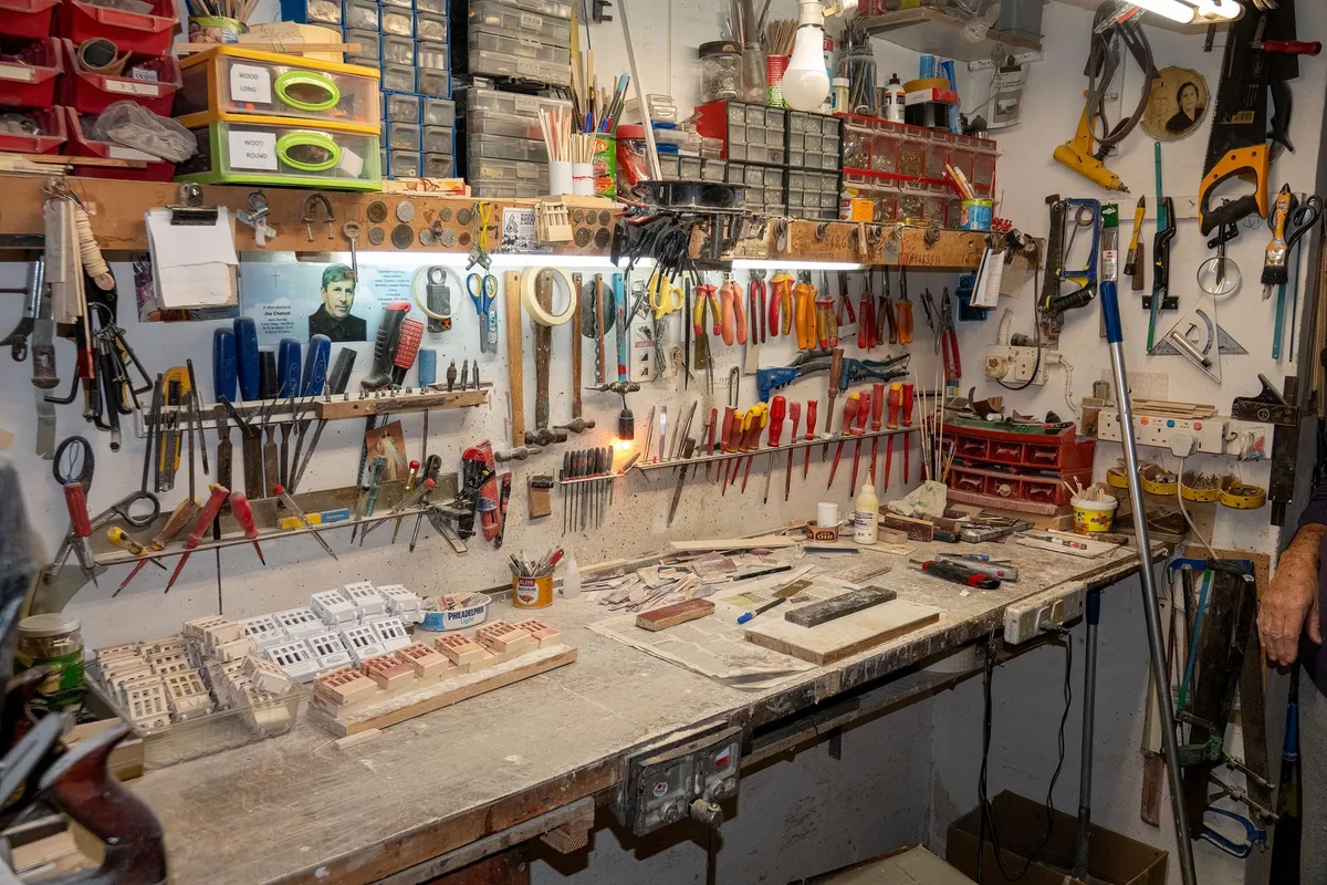 magnetic strip holding wrenches above garage workbench