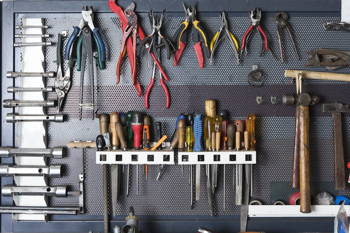 dark-painted pegboard on garage wall with hand tools and hooks