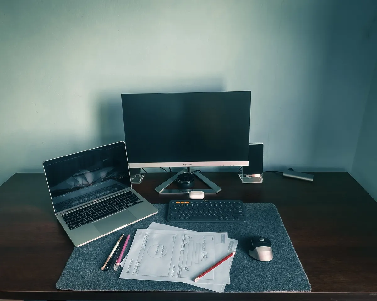 small corner desk with lamp and notebook beside window