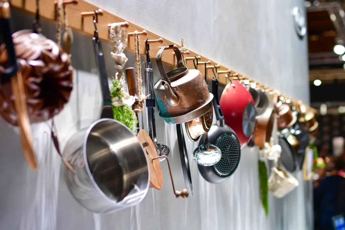 over-door rack holding pot lids inside cabinet