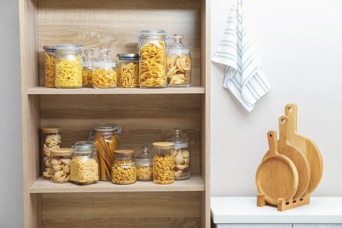 clear stackable bins labeled inside kitchen cabinet