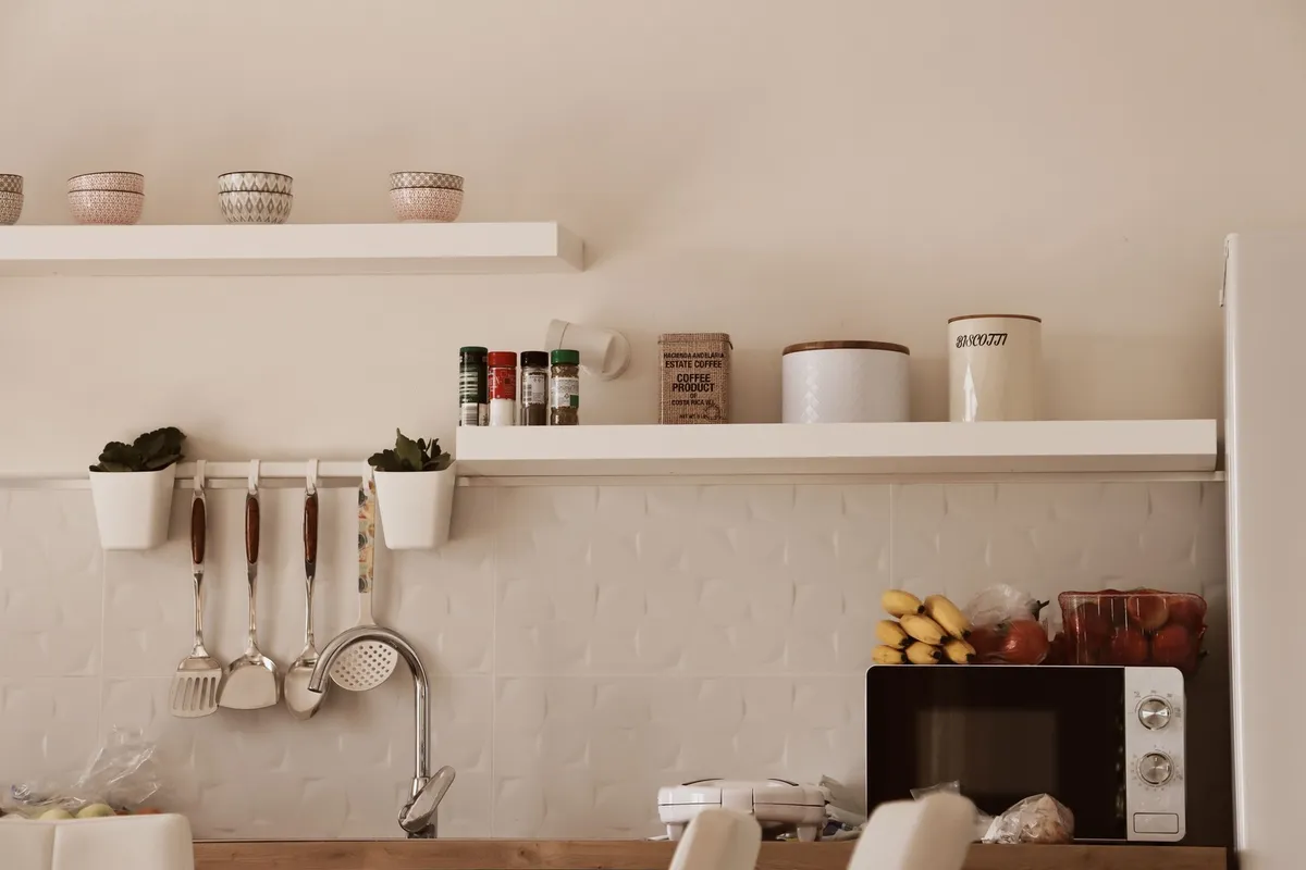narrow floating shelf above kitchen counter with mugs and bowls