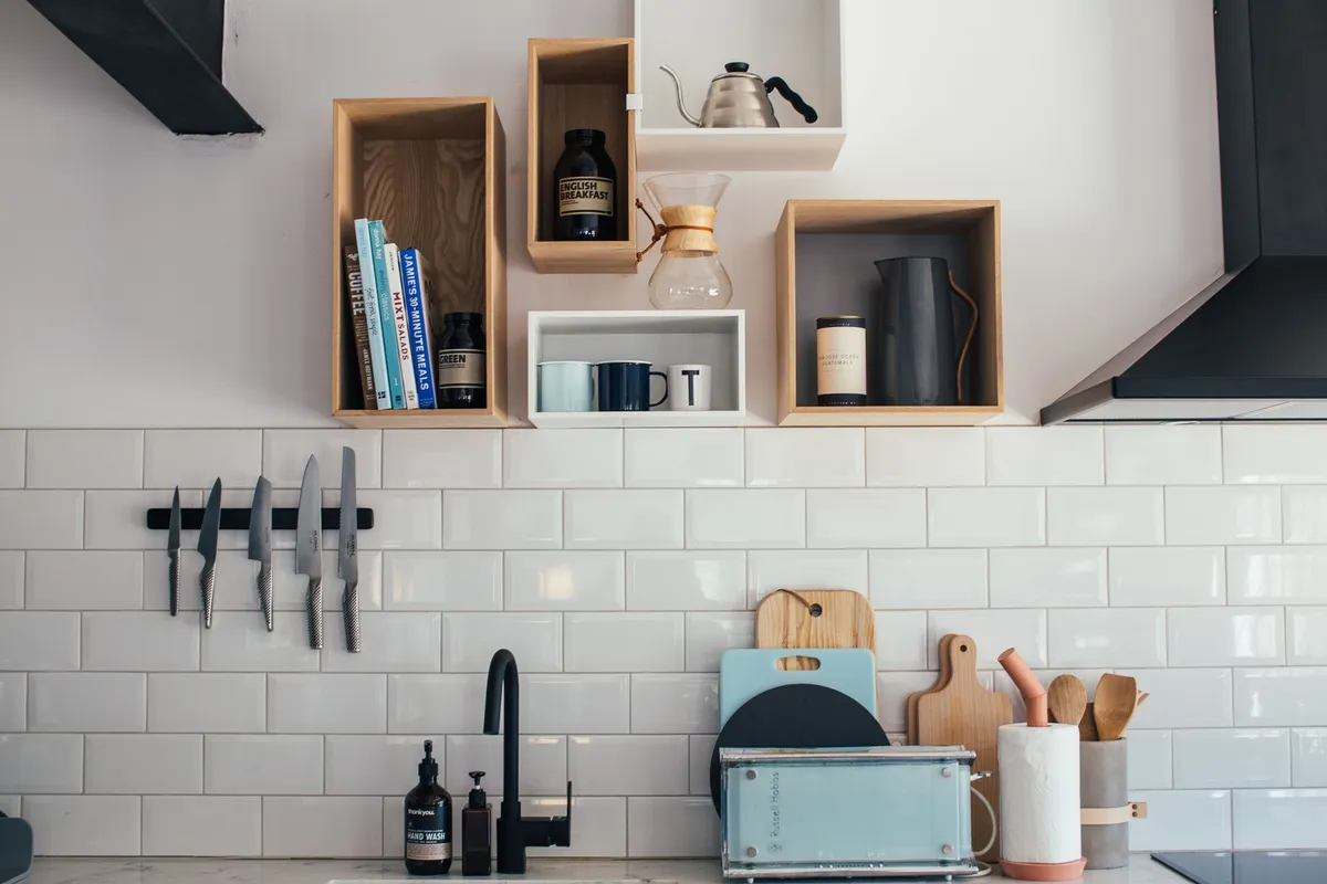 mugs hanging from hooks under kitchen cabinet