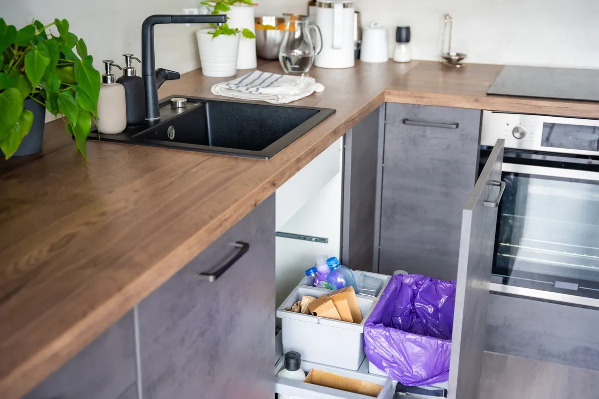 slim pull-out drawer organizer beside sink pipes