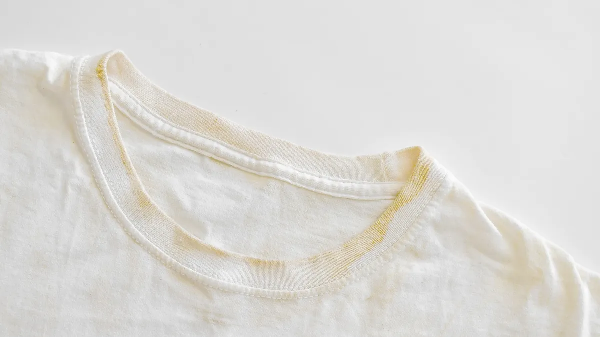 box of baking soda next to folded white towels on laundry room shelf