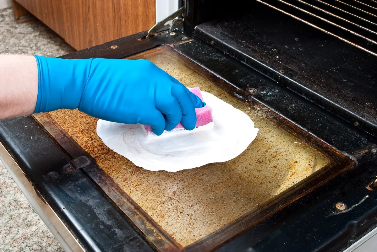 grimy oven interior with baked-on grease and dark stains on walls and bottom