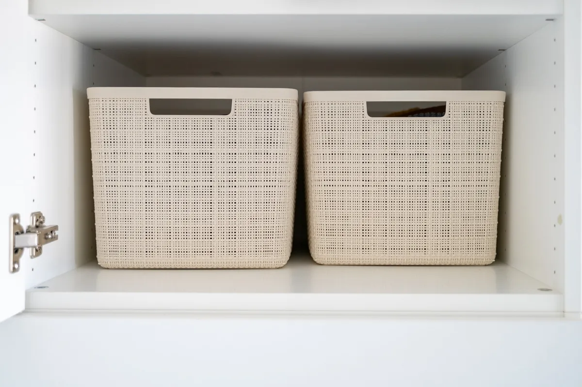 white laundry room floating shelf above washer with baskets