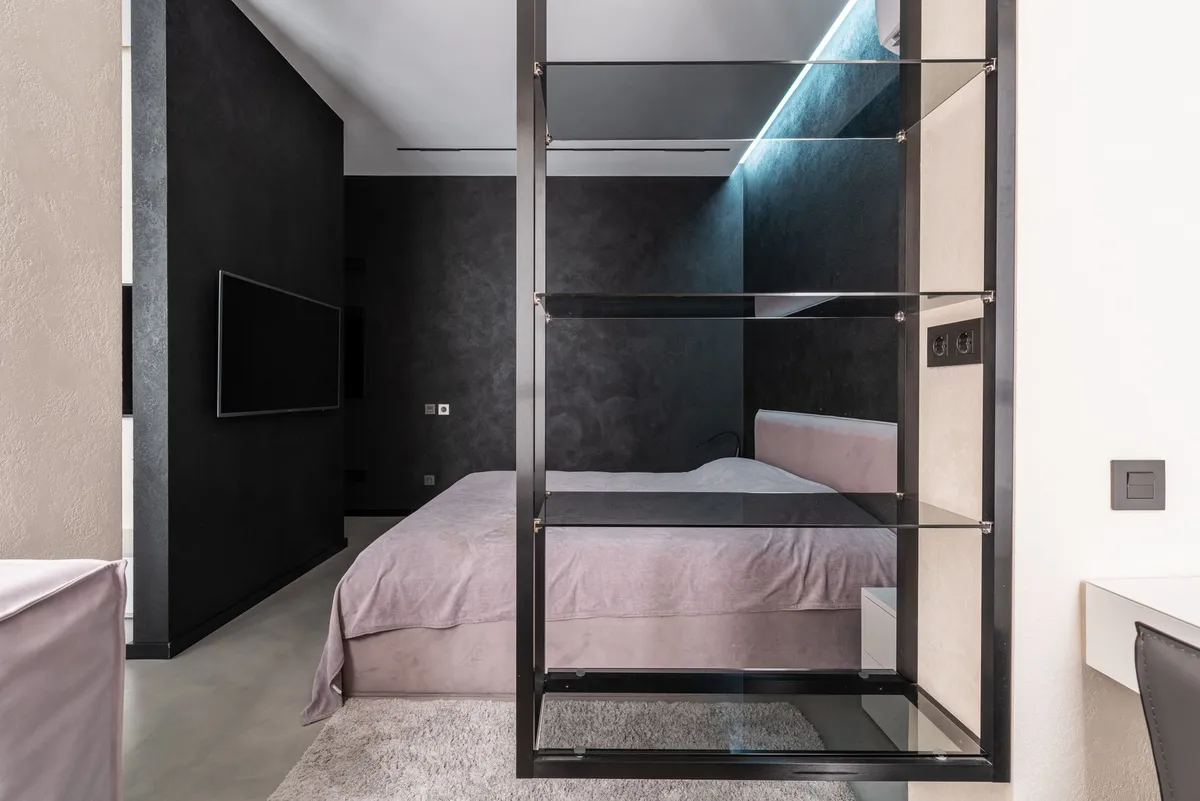 tall narrow white bookshelf in bedroom corner with baskets and books
