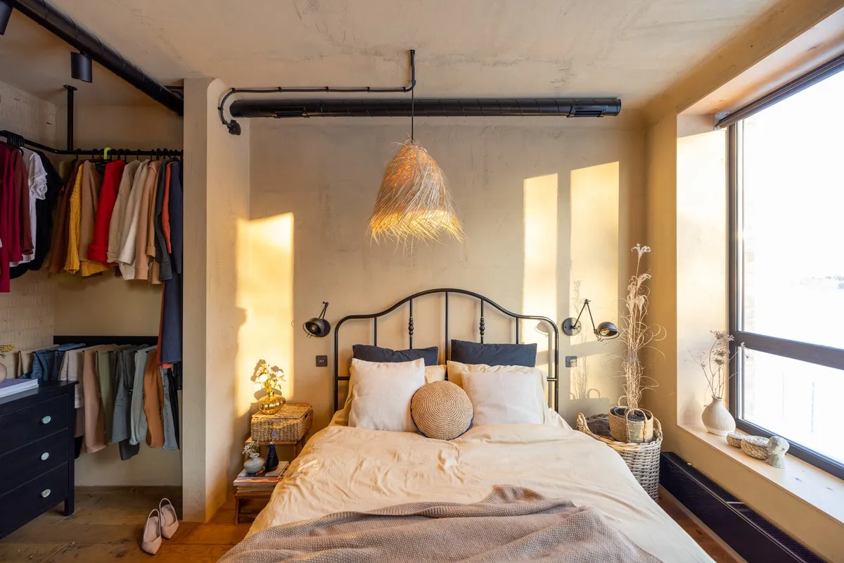 storage ottoman at foot of bed in small bedroom