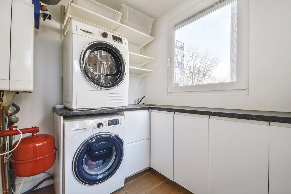 slim 3 bin rolling laundry cart in corner of small room