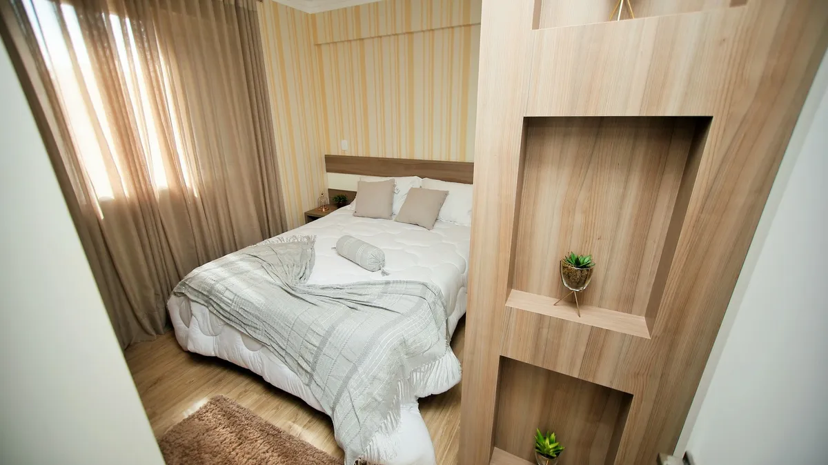 tall white wardrobe against bedroom wall with doors open showing organized interior